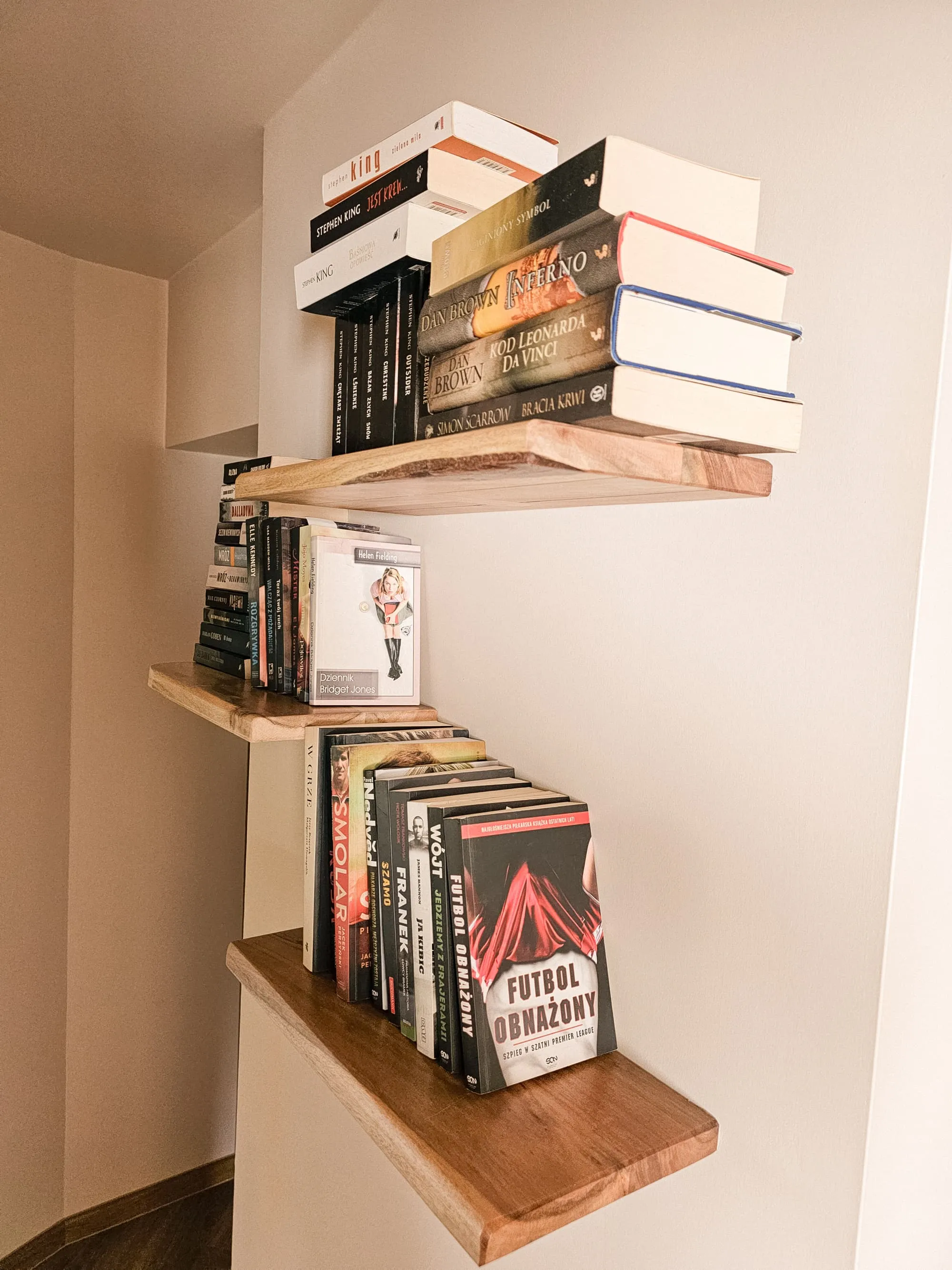 Drewniane półki z książkami w korytarzu Apartamentu Boho