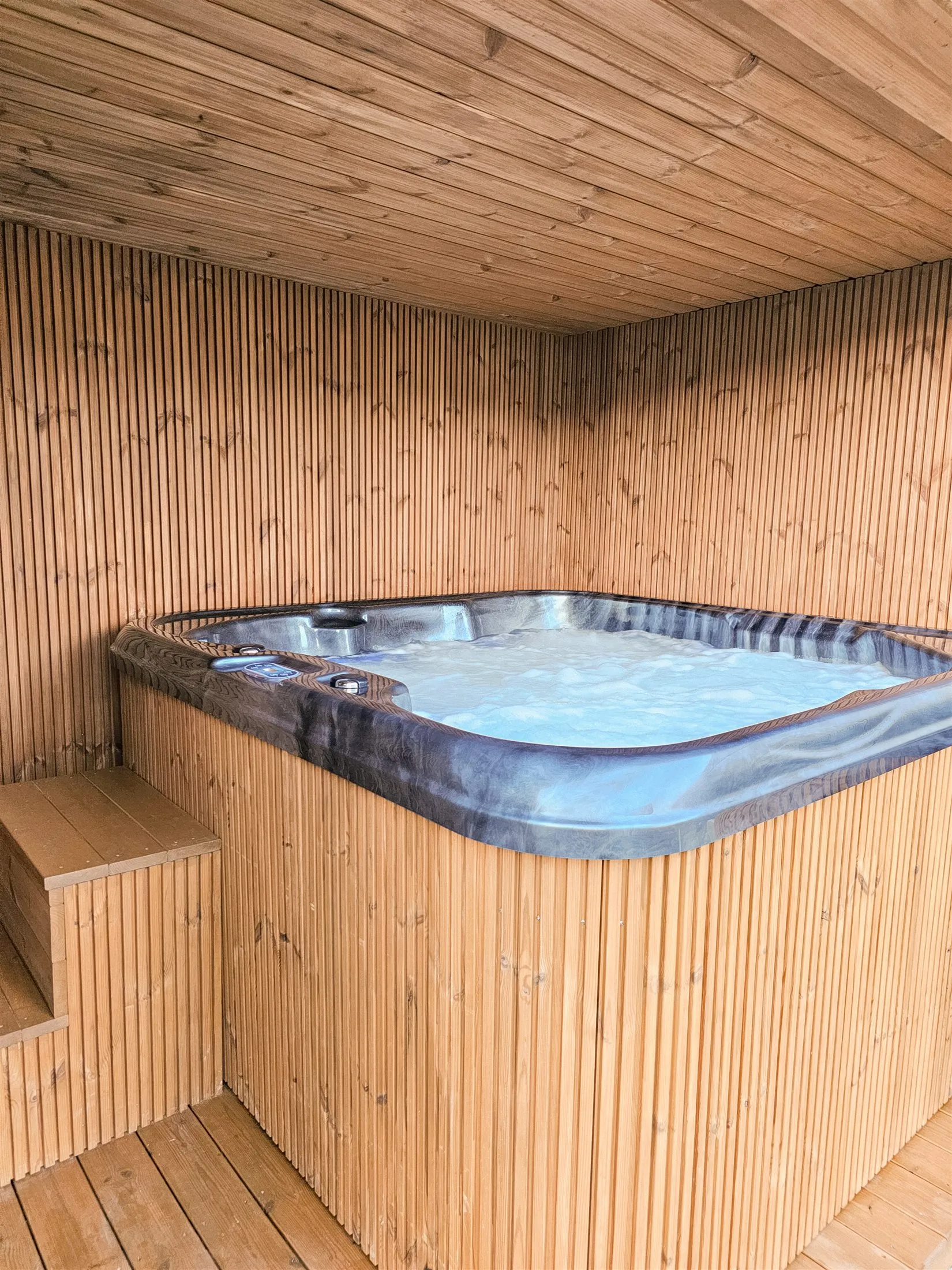 Jacuzzi w drewnianej Strefie Spa z podświetloną wodą